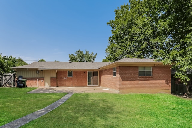 back of property with a yard and a patio area