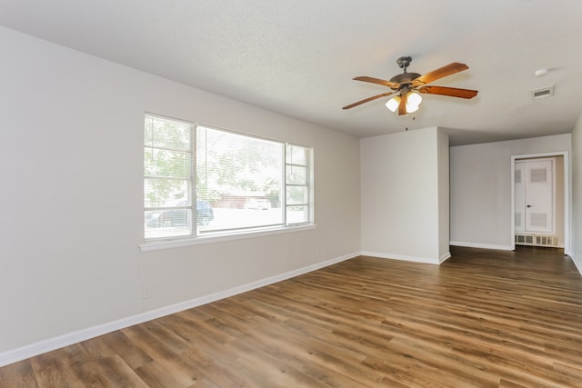 empty room featuring ceiling fan, dark hardwood / wood-style flooring, and a textured ceiling