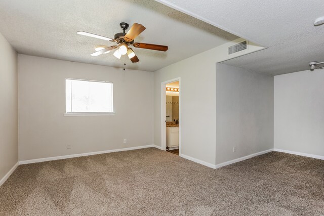 spare room featuring ceiling fan, carpet, and a textured ceiling