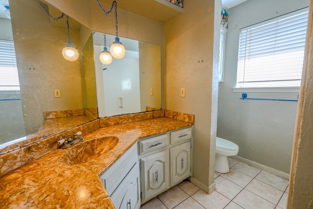 bathroom featuring toilet, vanity, tile patterned floors, and plenty of natural light