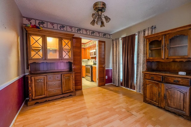 office with ceiling fan, a textured ceiling, and light wood-type flooring