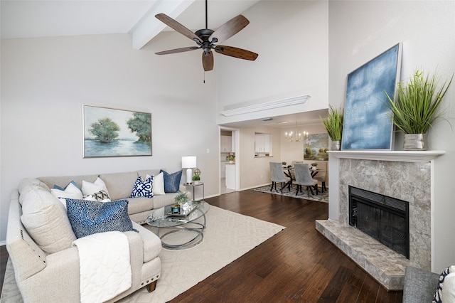 living room with beam ceiling, a premium fireplace, high vaulted ceiling, wood-type flooring, and ceiling fan with notable chandelier