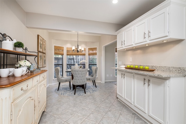 dining space featuring light tile patterned floors and an inviting chandelier