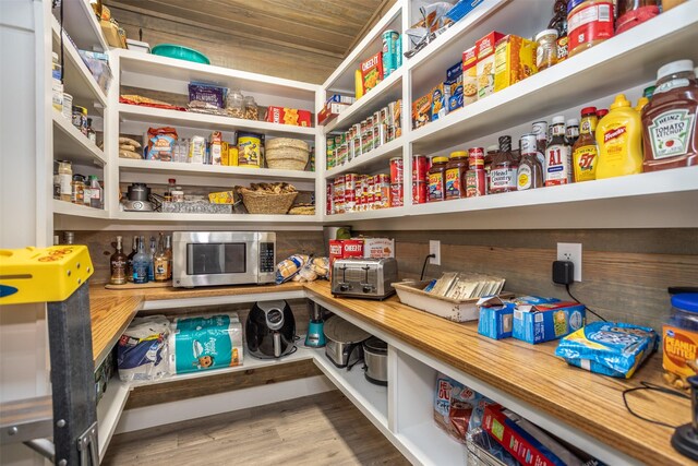 laundry room with independent washer and dryer, cabinets, wooden walls, and light hardwood / wood-style flooring