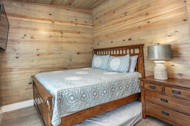 bedroom with dark hardwood / wood-style flooring, wood ceiling, wooden walls, and ceiling fan