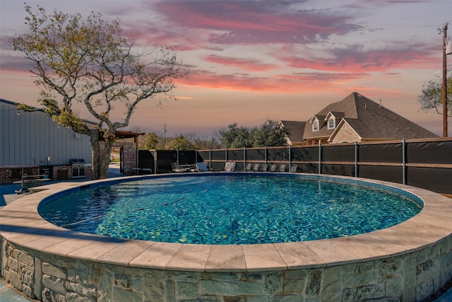 view of pool at dusk