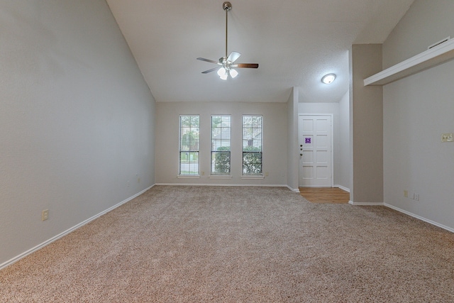 carpeted empty room featuring ceiling fan and high vaulted ceiling