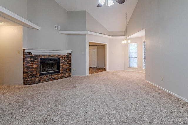 unfurnished living room with a brick fireplace, ceiling fan with notable chandelier, carpet floors, and high vaulted ceiling