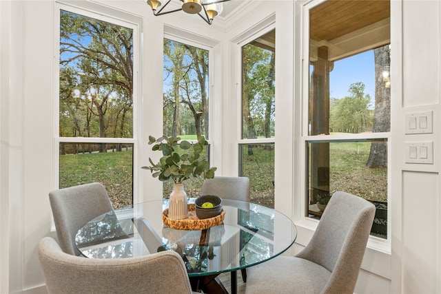 sunroom / solarium featuring a chandelier