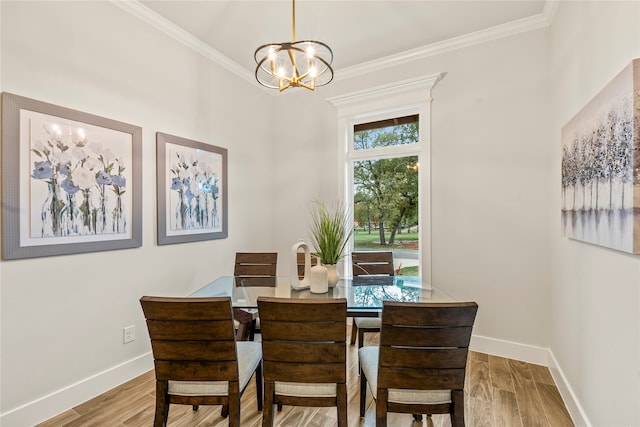 dining room with light hardwood / wood-style floors, ornamental molding, and a chandelier