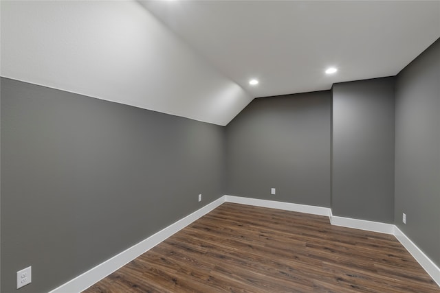 bonus room featuring dark wood-type flooring and vaulted ceiling