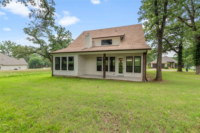 rear view of house featuring a patio area and a lawn