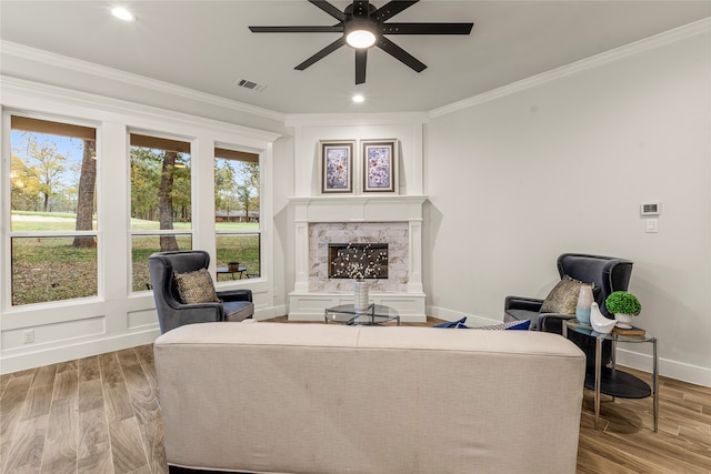 living room with crown molding, ceiling fan, and light wood-type flooring