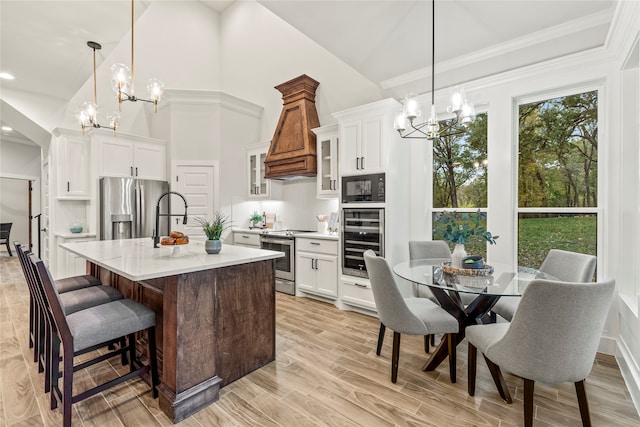 kitchen featuring wine cooler, a center island with sink, decorative light fixtures, and appliances with stainless steel finishes