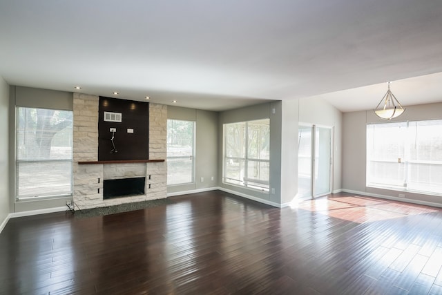 unfurnished living room with a stone fireplace, hardwood / wood-style floors, and lofted ceiling