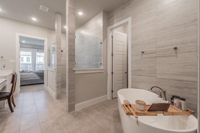 bathroom featuring tile patterned flooring, vanity, separate shower and tub, and tile walls