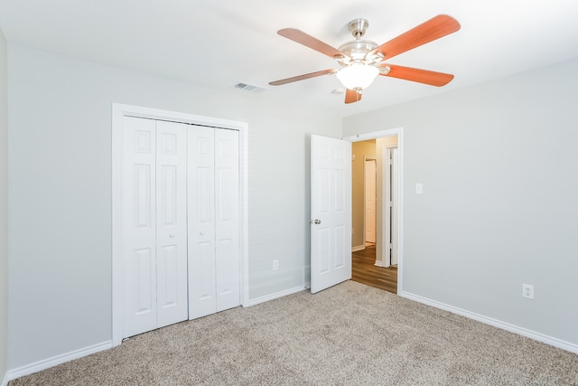 unfurnished bedroom featuring ceiling fan, light carpet, and a closet