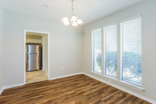 empty room with a chandelier and hardwood / wood-style floors