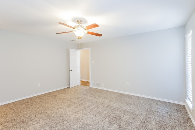 unfurnished room with ceiling fan and carpet