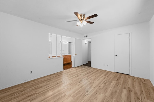 unfurnished bedroom featuring light wood-type flooring, a closet, ensuite bath, and ceiling fan