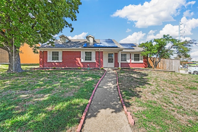 single story home featuring solar panels and a front lawn