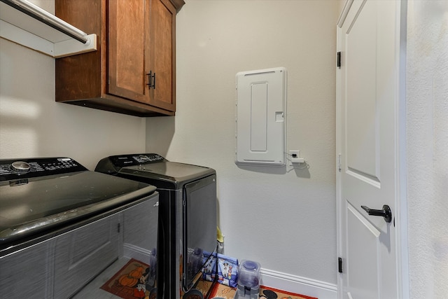 laundry area featuring cabinets, electric panel, and washer and clothes dryer