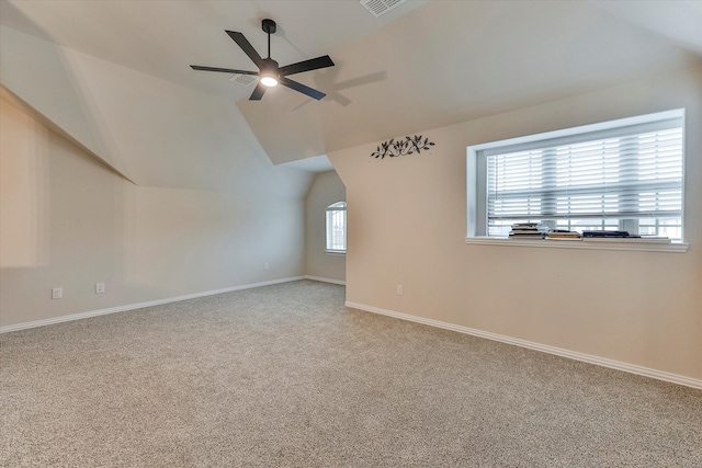 additional living space featuring ceiling fan, carpet, a healthy amount of sunlight, and lofted ceiling