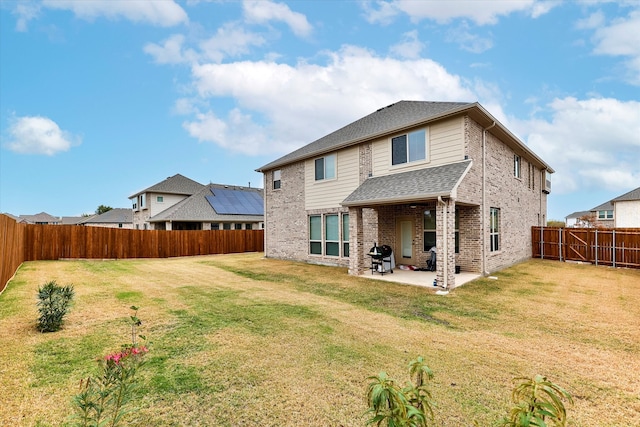 back of property with a lawn and a patio