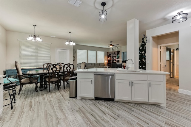 kitchen with pendant lighting, dishwasher, white cabinetry, and sink