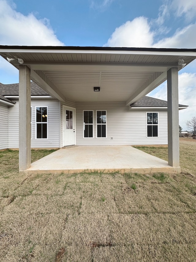 back of house featuring a patio area and a lawn