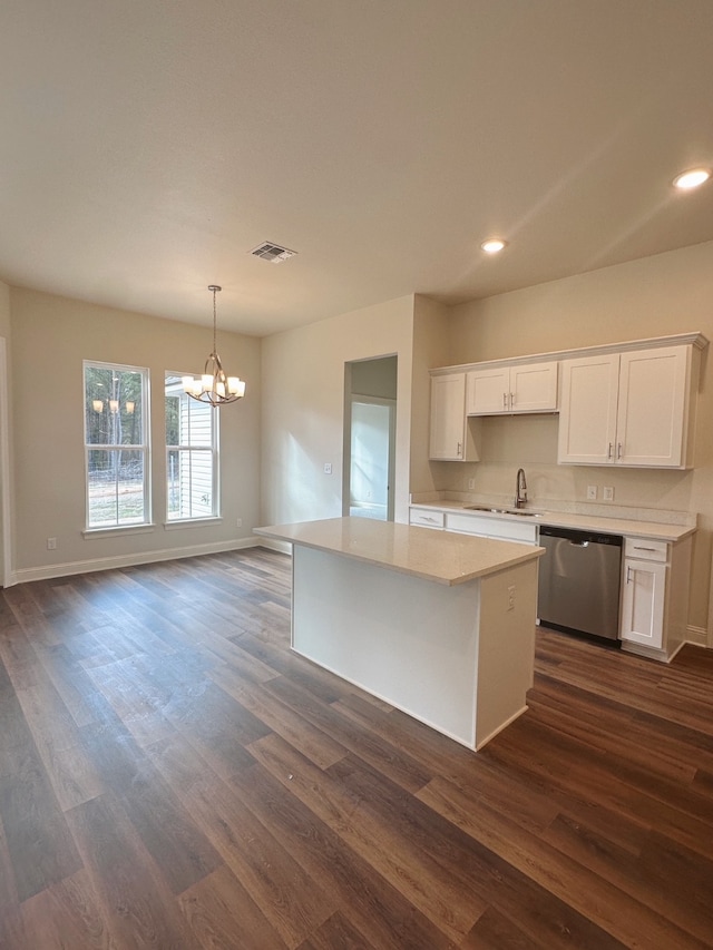 kitchen featuring open floor plan, light countertops, stainless steel dishwasher, and white cabinets