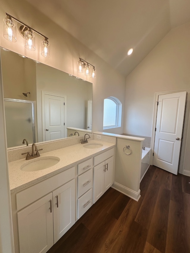 bathroom with vaulted ceiling, a sink, a bath, and a shower stall