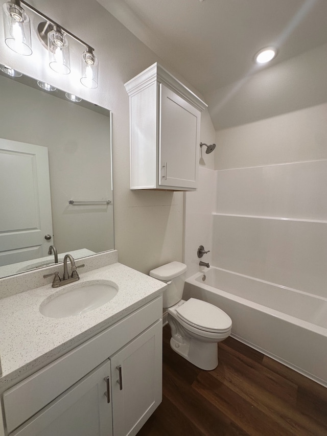 full bath with shower / bathtub combination, lofted ceiling, toilet, vanity, and wood finished floors