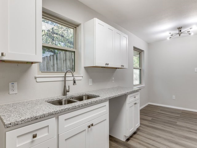 kitchen with white cabinets, plenty of natural light, and sink