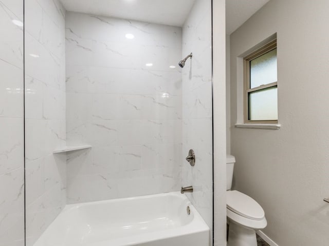 bathroom featuring toilet and tiled shower / bath