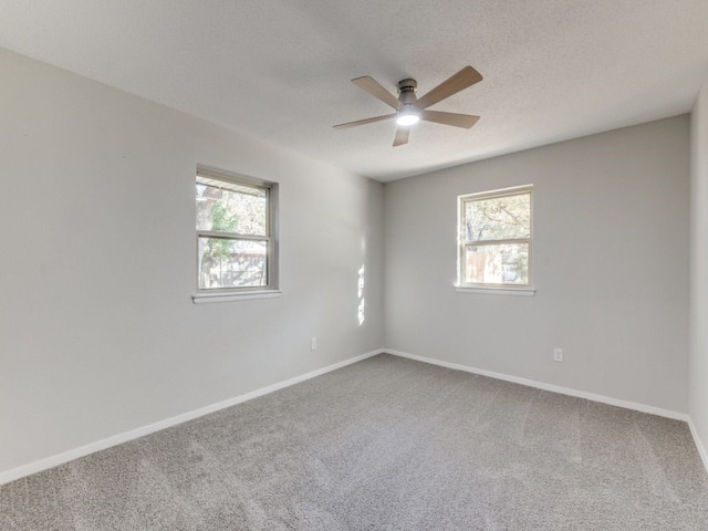 carpeted spare room with a textured ceiling and ceiling fan