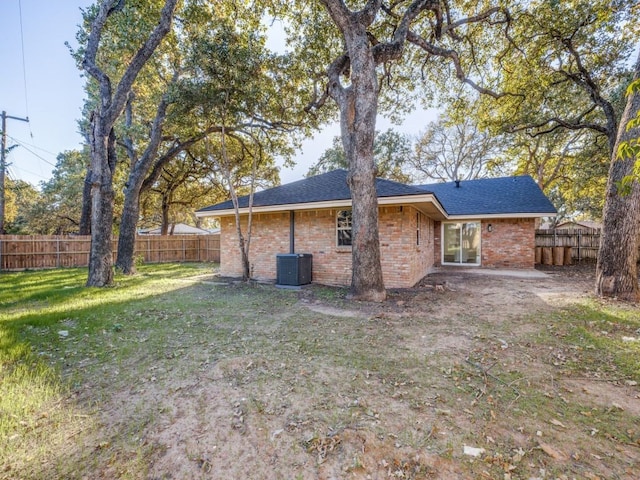 back of house featuring a lawn and central AC unit