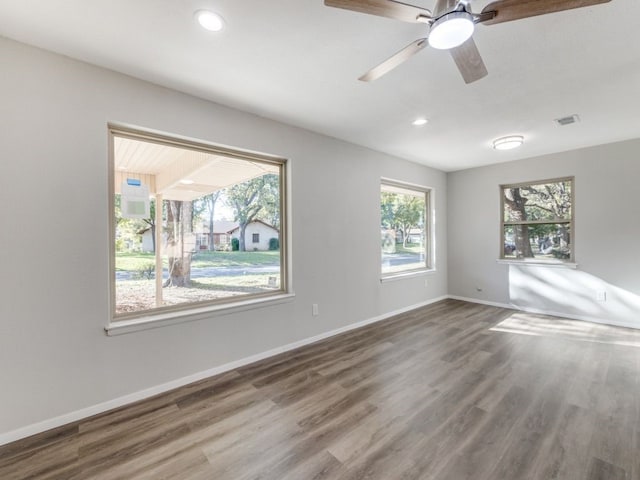 spare room featuring hardwood / wood-style flooring, plenty of natural light, and ceiling fan