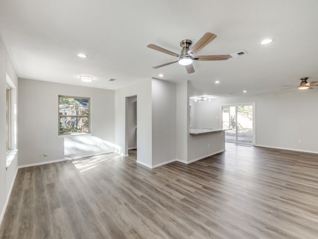 unfurnished living room featuring hardwood / wood-style floors, ceiling fan, and a wealth of natural light