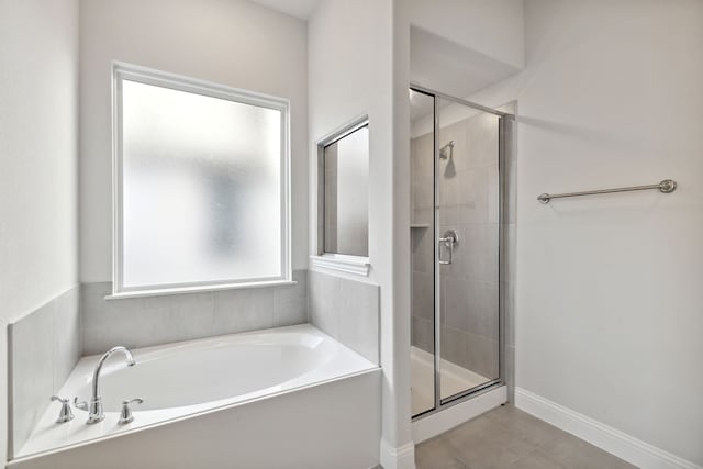 bathroom with tile patterned flooring and separate shower and tub