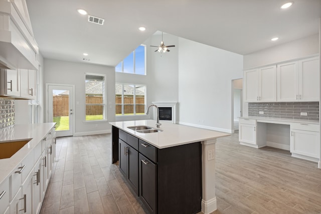 kitchen featuring white cabinetry, sink, and a kitchen island with sink