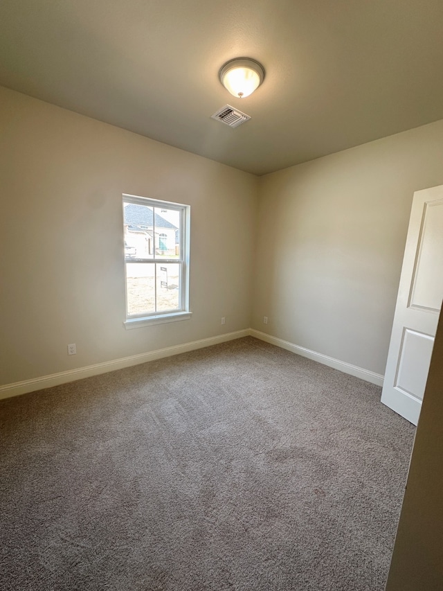 spare room featuring baseboards, visible vents, and carpet flooring