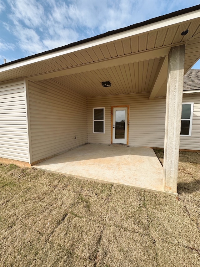 property entrance featuring a yard and a patio