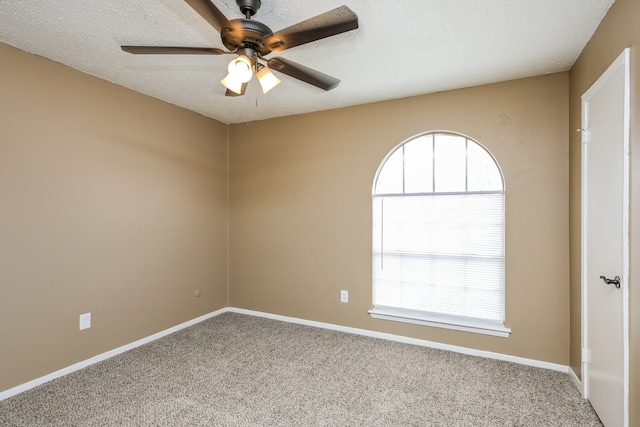 carpeted empty room featuring ceiling fan and a textured ceiling