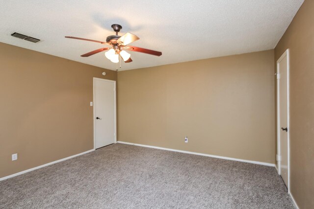 carpeted empty room with ceiling fan and a textured ceiling