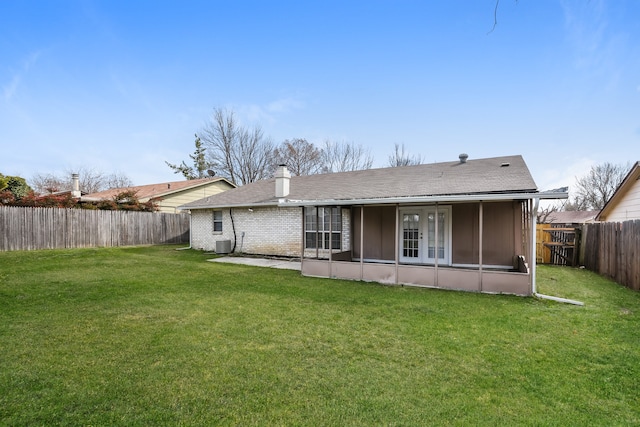 rear view of house featuring a yard, cooling unit, and a sunroom