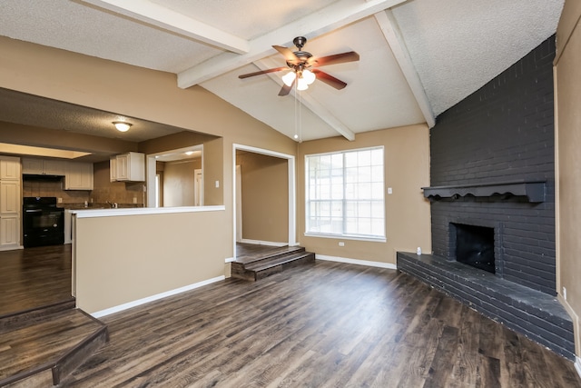 unfurnished living room featuring vaulted ceiling with beams, dark wood-type flooring, a textured ceiling, and a brick fireplace