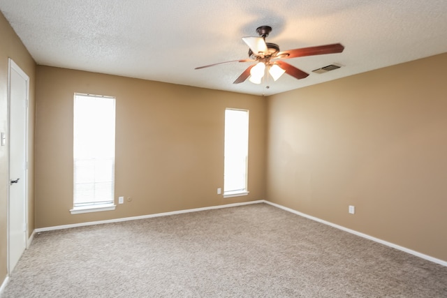 carpeted spare room featuring ceiling fan and a textured ceiling