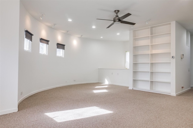 carpeted spare room featuring ceiling fan and built in features