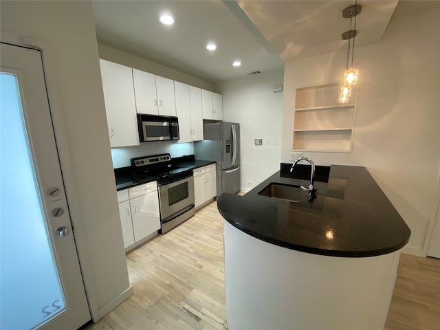 kitchen featuring pendant lighting, sink, light wood-type flooring, white cabinetry, and stainless steel appliances